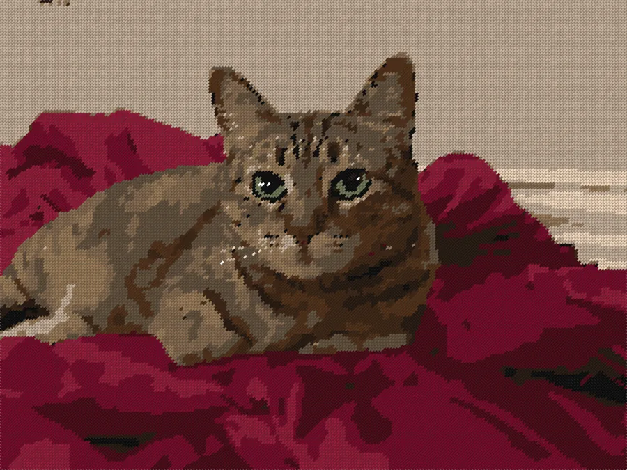 A green-eyed tabby cat lying on red velvet, as a stitched needlepoint preview in DMC reds, browns and creams